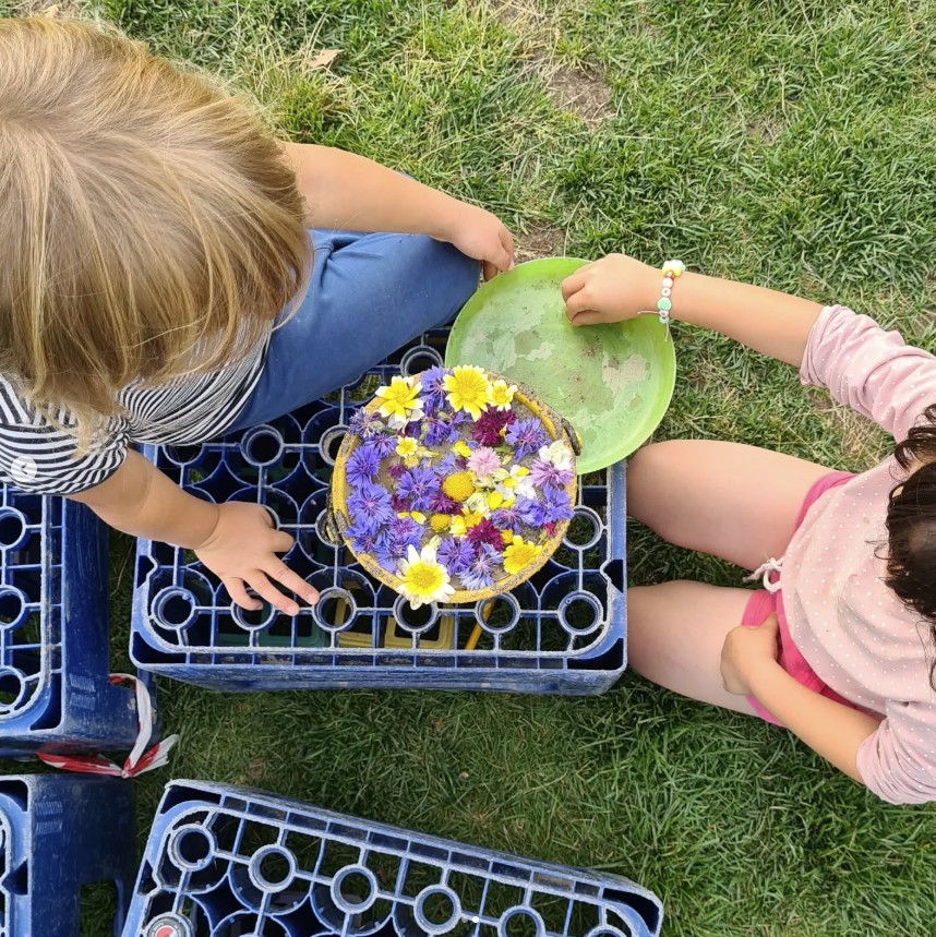 Barn lager blomsterkake av kornblomster og prestekrager