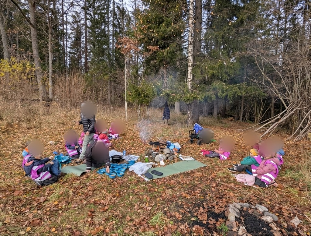 Barn samlet rundt bålet i skogen om høsten