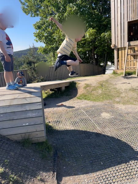 Barn hopper fra trekasse på uteområdet
