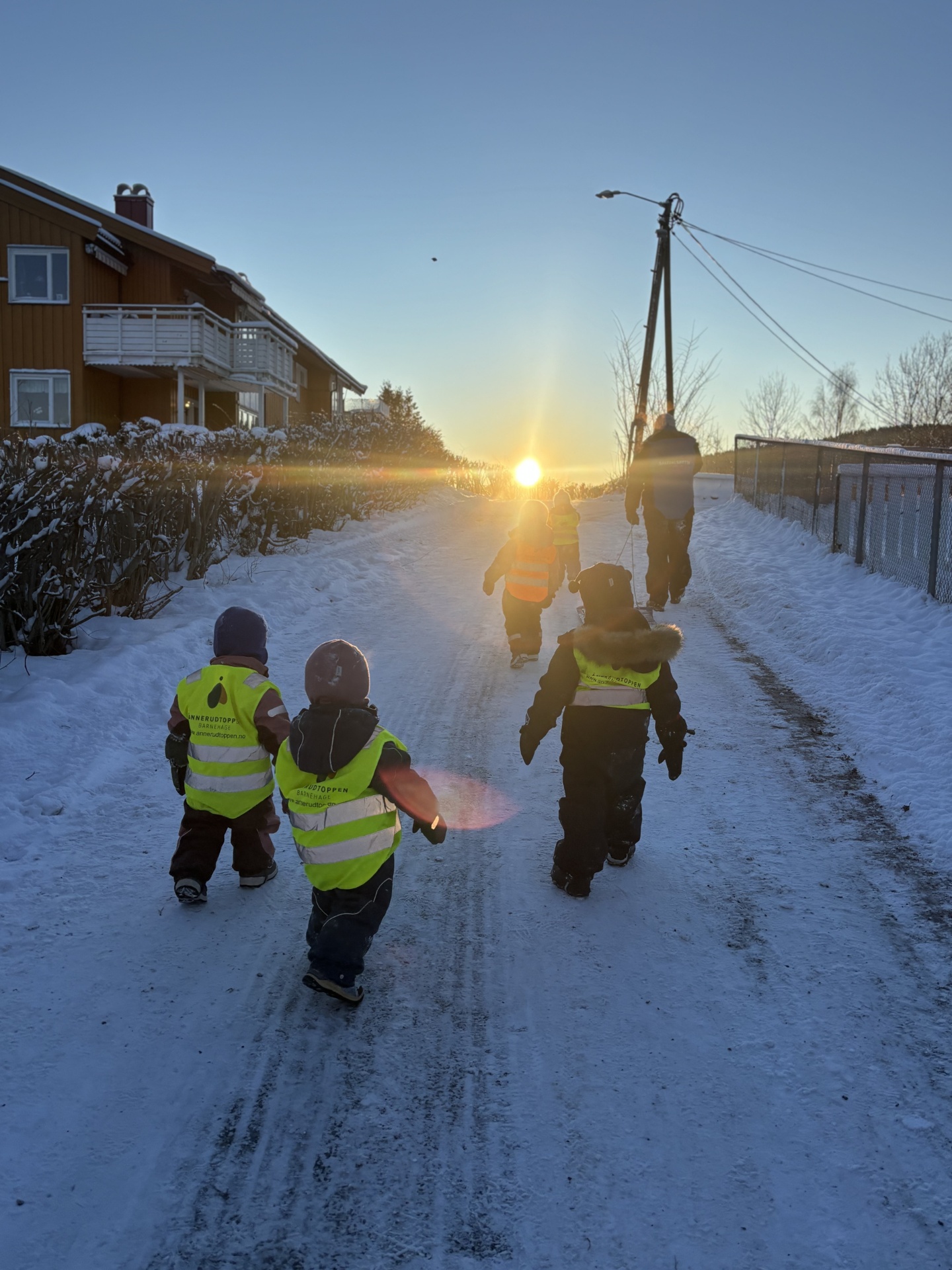 Barn går på vintertur mot soloppgangen